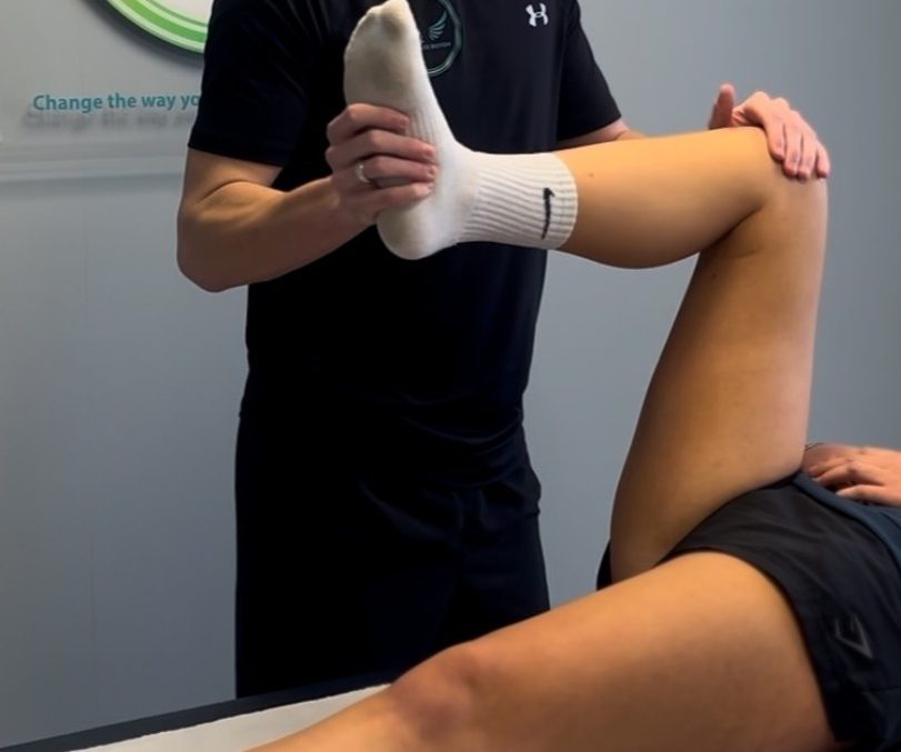 Sports and clinical therapist performing a hip assessment for hip pain treatment in Monmouthshire
